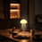 Jellyfish-shaped lamp on a table with food in a dimly lit room