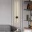 Modern wall sconce in a stylish interior setting with a bookshelf and sofa.