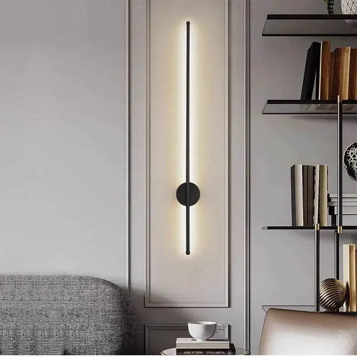 Modern wall sconce in a stylish interior setting with a bookshelf and sofa.