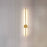 Modern wall lamp with a gold finish on a neutral wall